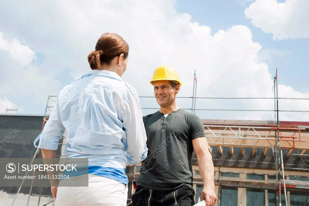 Headline: Foreman and client shaking hands on construction site