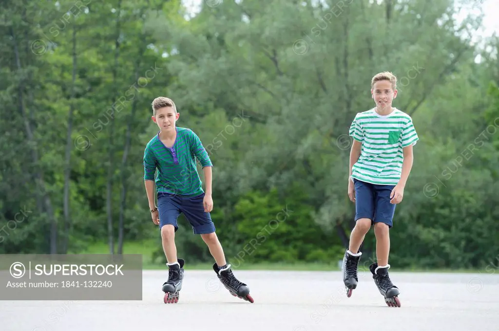 Headline: Two boys with in-line skates on a sports place