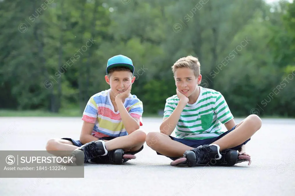 Headline: Two boys with in-line skates on a sports place