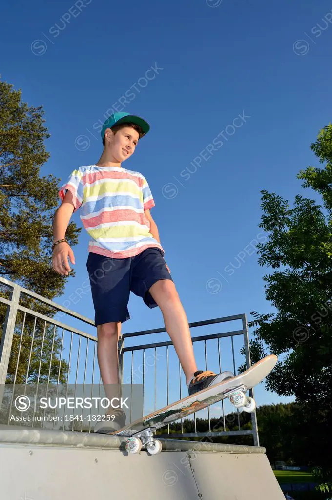 Headline: Boy with skateboard in a skatepark