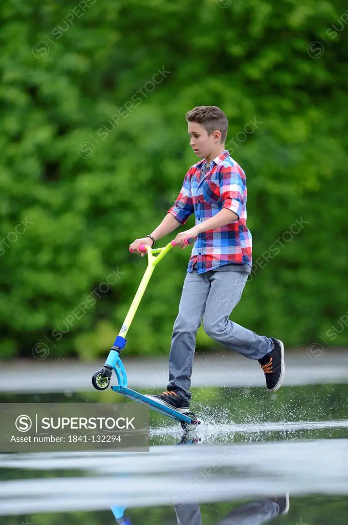 Headline: Boy with scooter on a rainy day