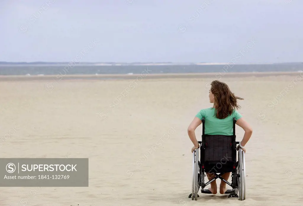 Female wheelchair user on the beach.