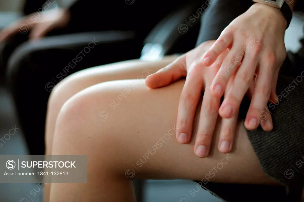 Sexual harrassment at work: A businessman is touching his female co-worker's leg.