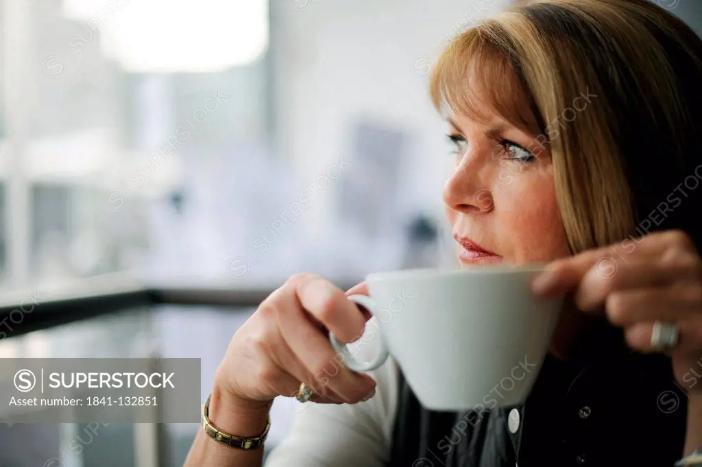 Woman in her late fifties in a cafe.