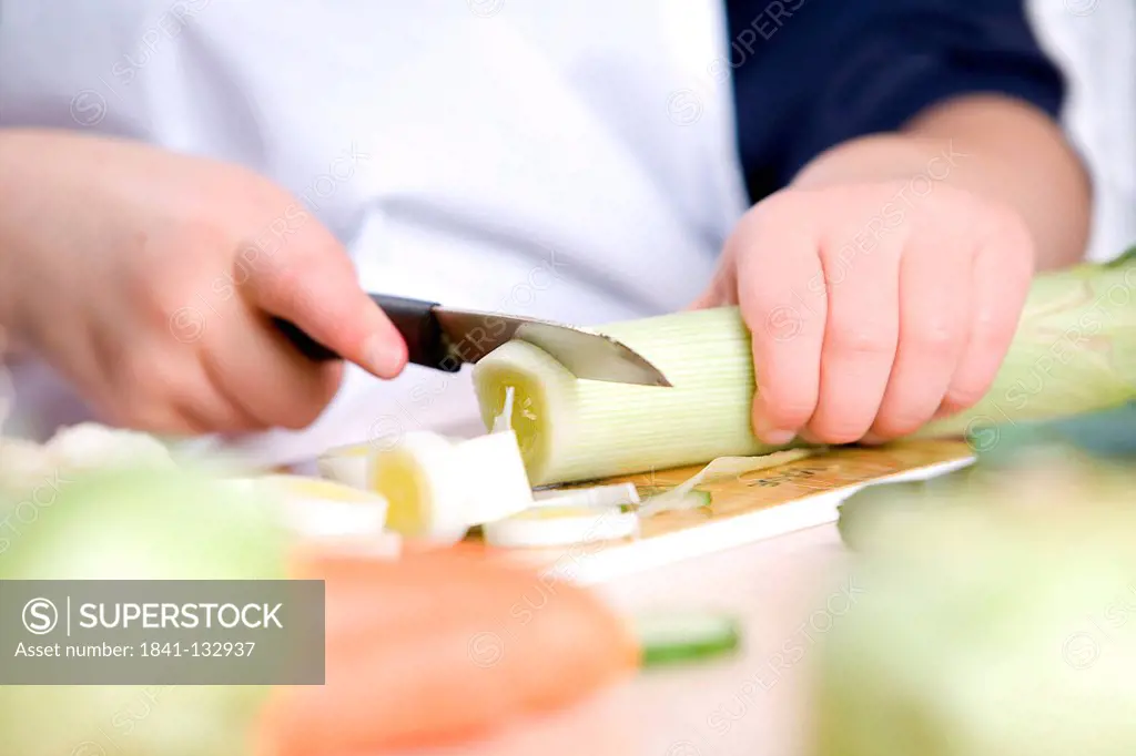 Hands are cutting vegetables.
