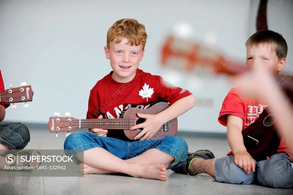 At music school. Children with small guitars.