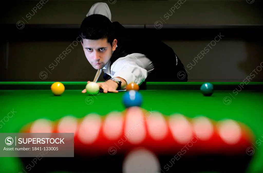 Snooker player playing snooker.