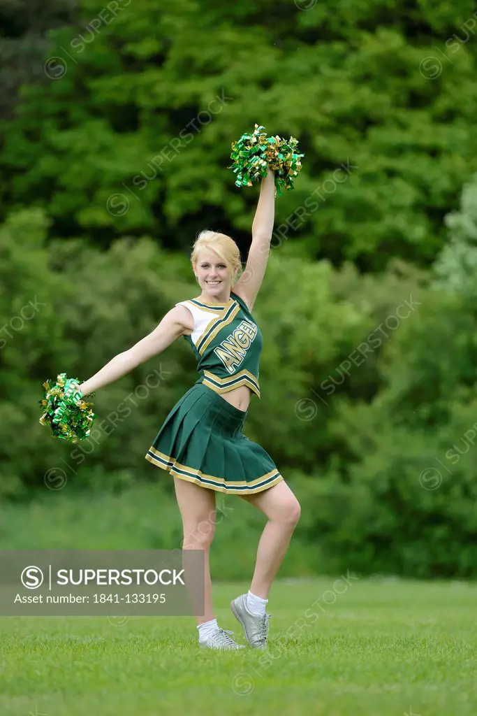 Young woman cheerleading on a meadow