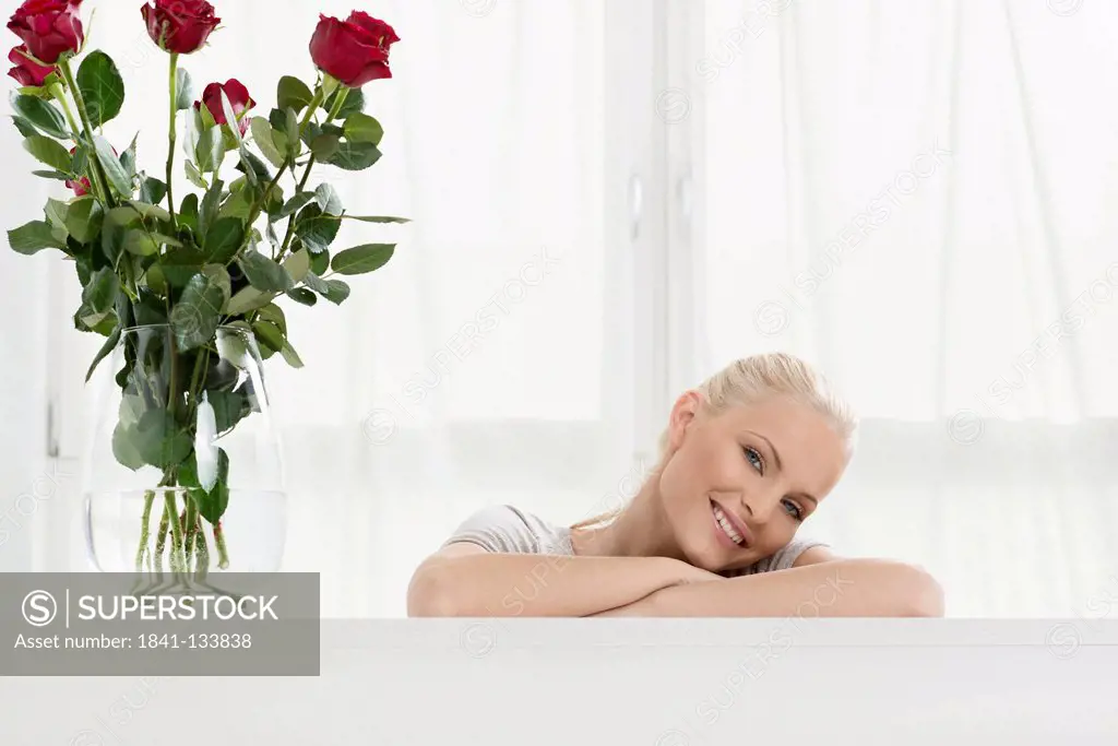 Smiling young blond woman with bunch of roses
