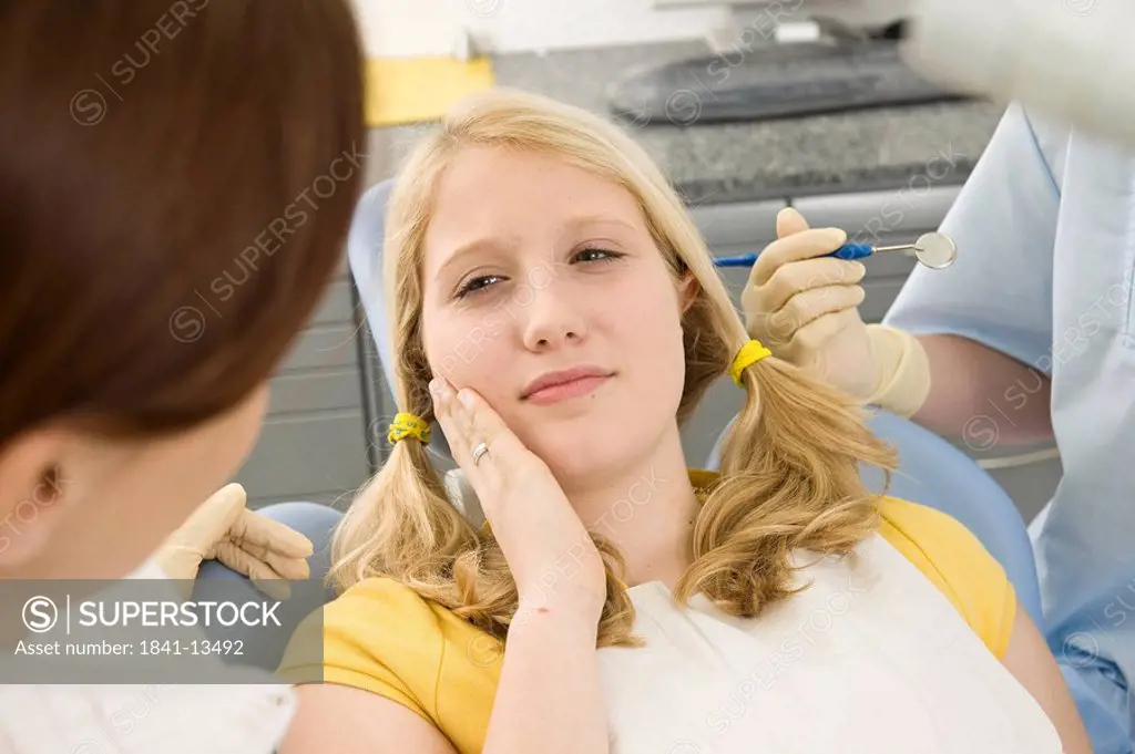 Female dentist and assistant examining patient