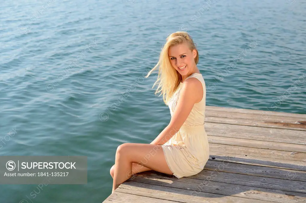 Young blond woman on a jetty at a lake, Styria, Austria