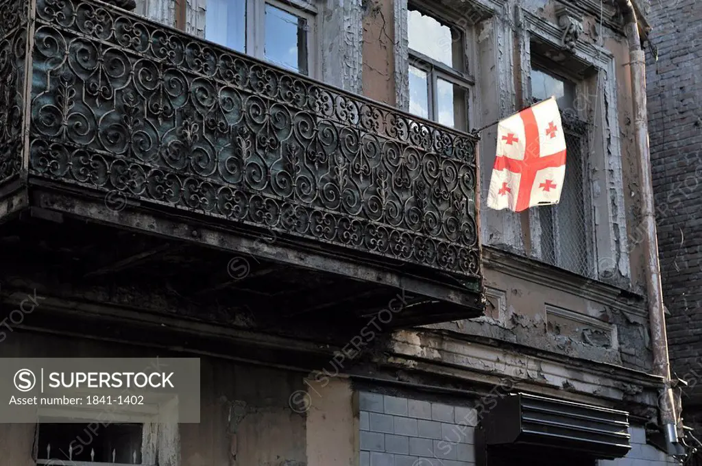Georgian flag at the balcony of an old building, Tbilisi, Georgia, low angle view
