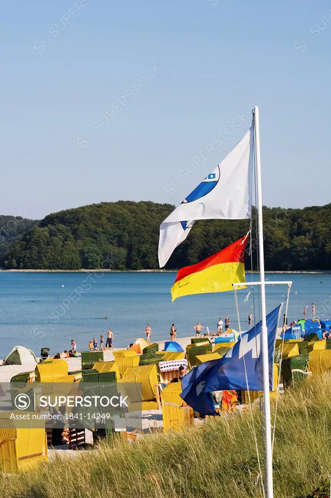 Tourists on the beach of Binz, flags in the foreground, Ruegen, Germany