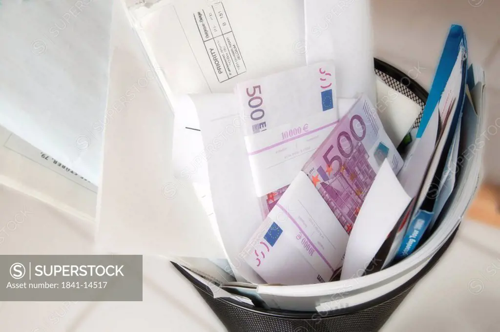 Five hundred Euro banknotes and papers in garbage bin