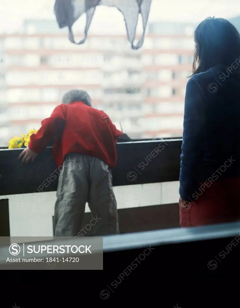 Child leaning out over a balcony