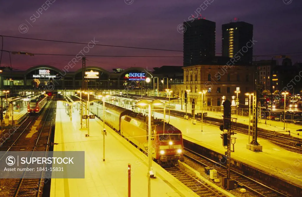 Trains at station lit up at dusk, Mainz, Germany