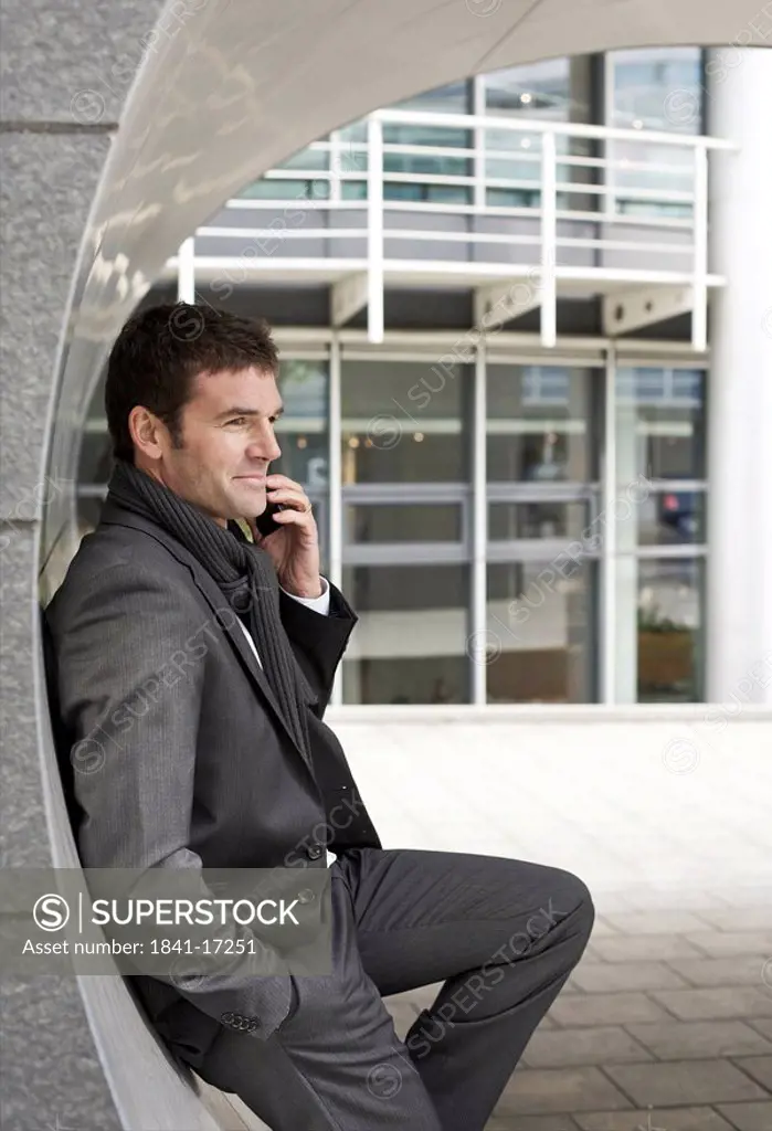 Businessman telephoning with mobile phone, side view