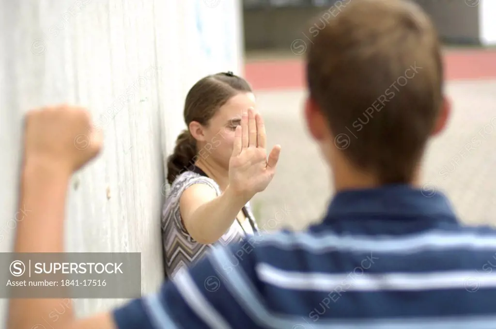 Side profile of teenage girl obstructing her friend with her hand