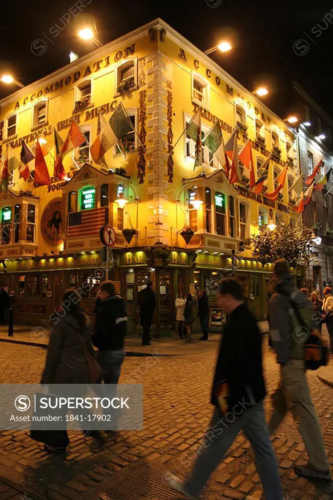 People walking in front of building lit up at night, Dublin, Republic of Ireland
