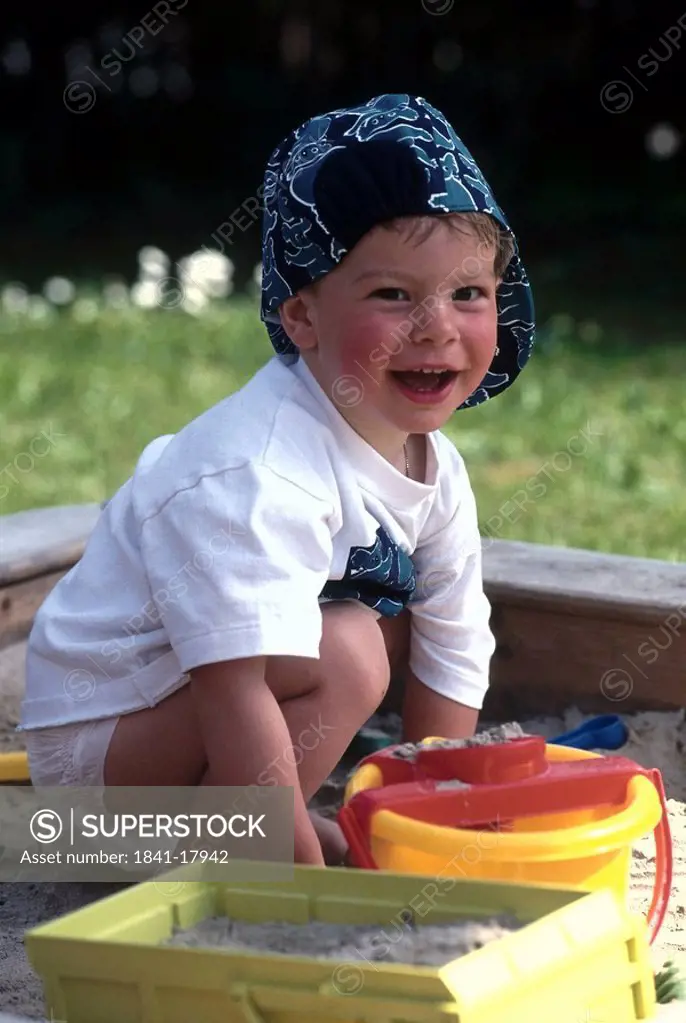 Portrait of boy playing with toys in sandpit