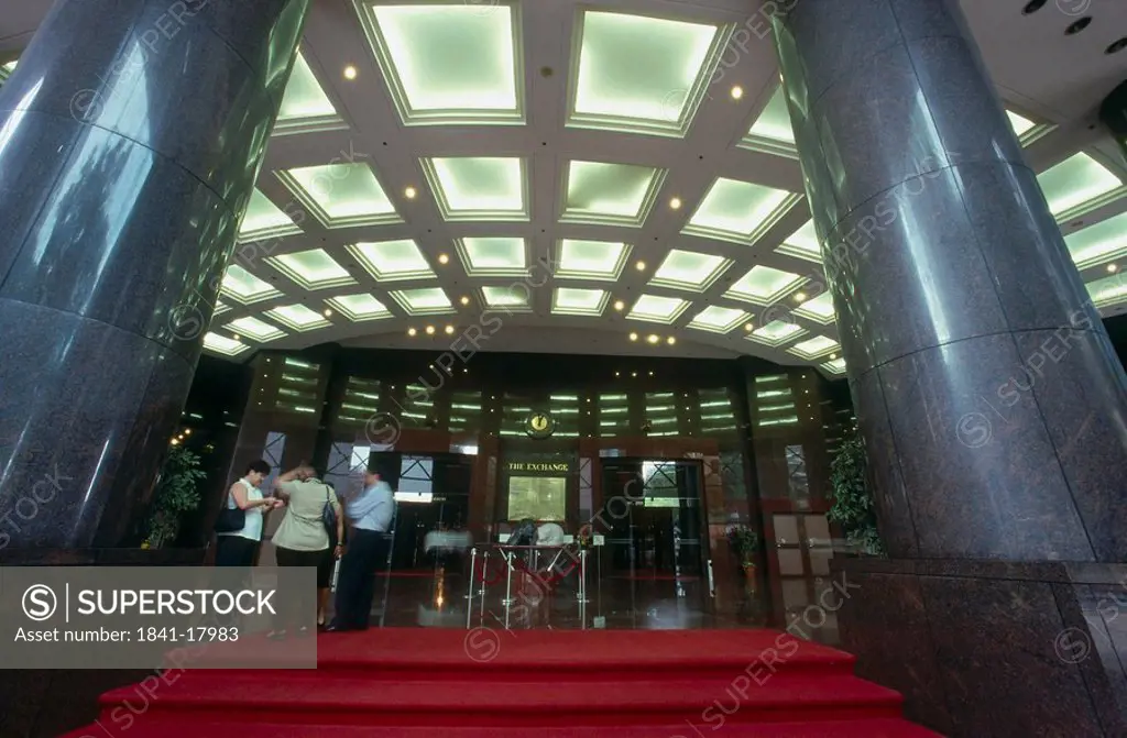 People standing at entrance of stock exchange building, Singapore