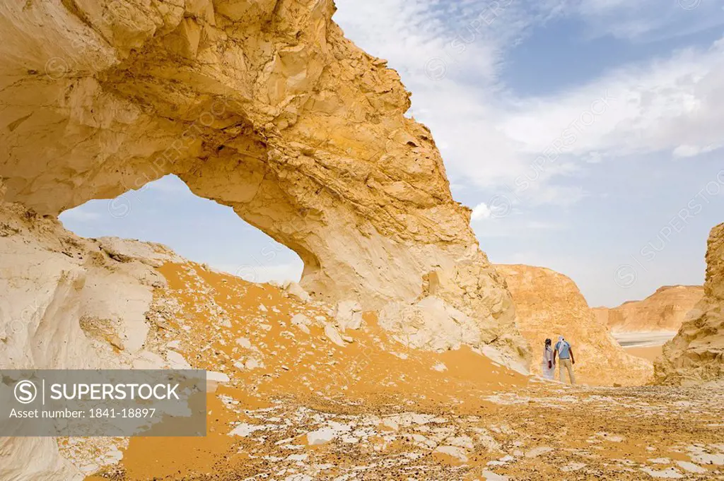 Two people standing near rock formation, Egypt