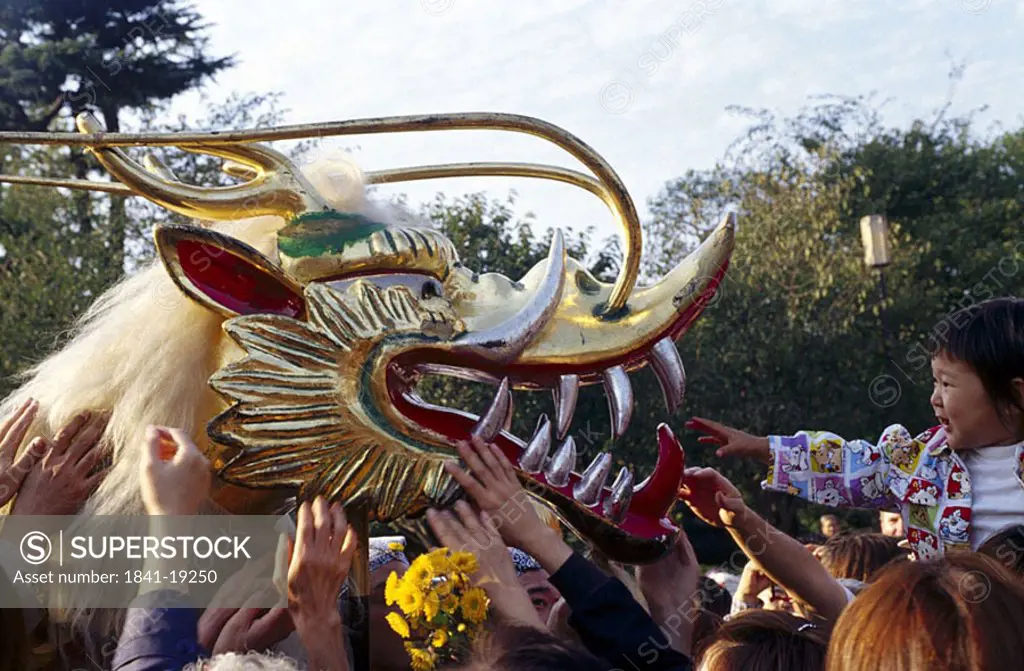 People touching golden dragon in festival, Senso_ji Temple, Asakusa, Tokyo, Japan