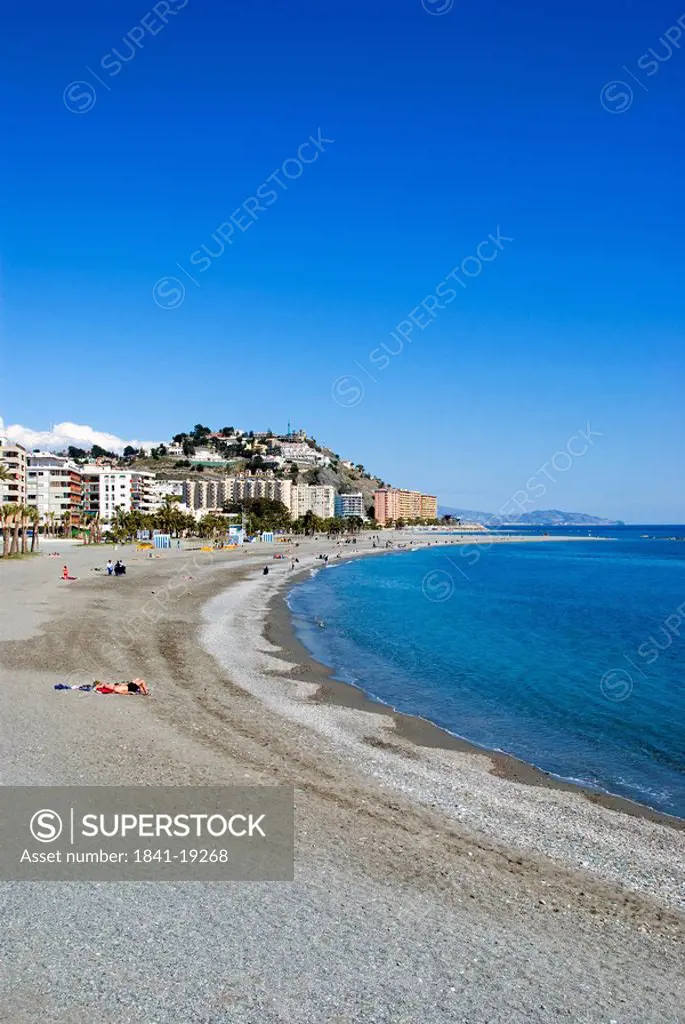 People on beach with town in background, Almunecar, Costa Del Sol, Granada Province, Andalusia, Spain