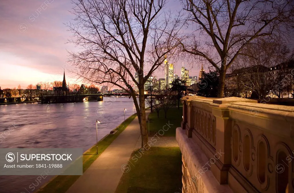 Bare trees and path along river at dusk, Alte Bruecke, Frankfurt, Germany