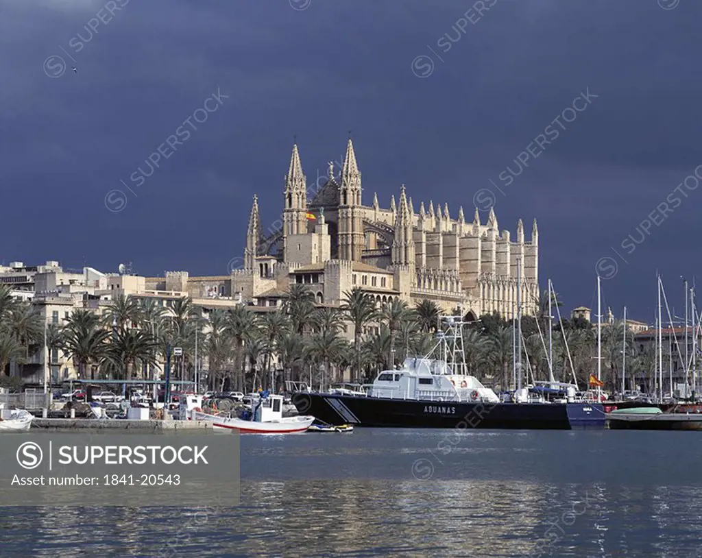 Boats in river with cathedral in background, Balearic Islands, Spain