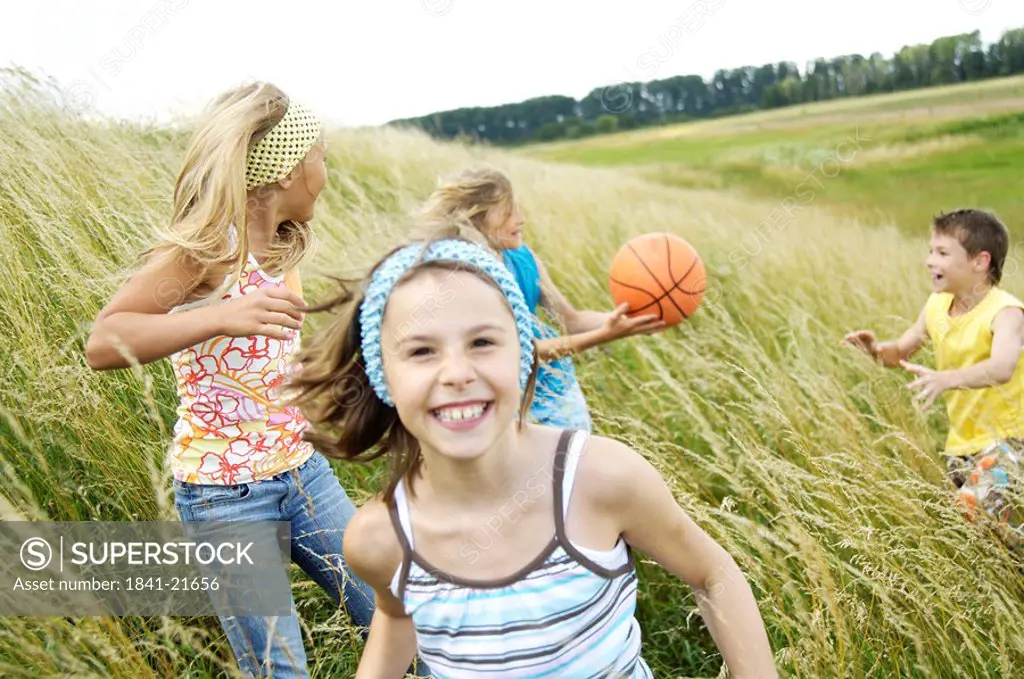 Four children playing in field