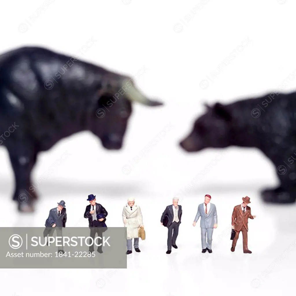 Figurines of businessmen with bear and bull in background