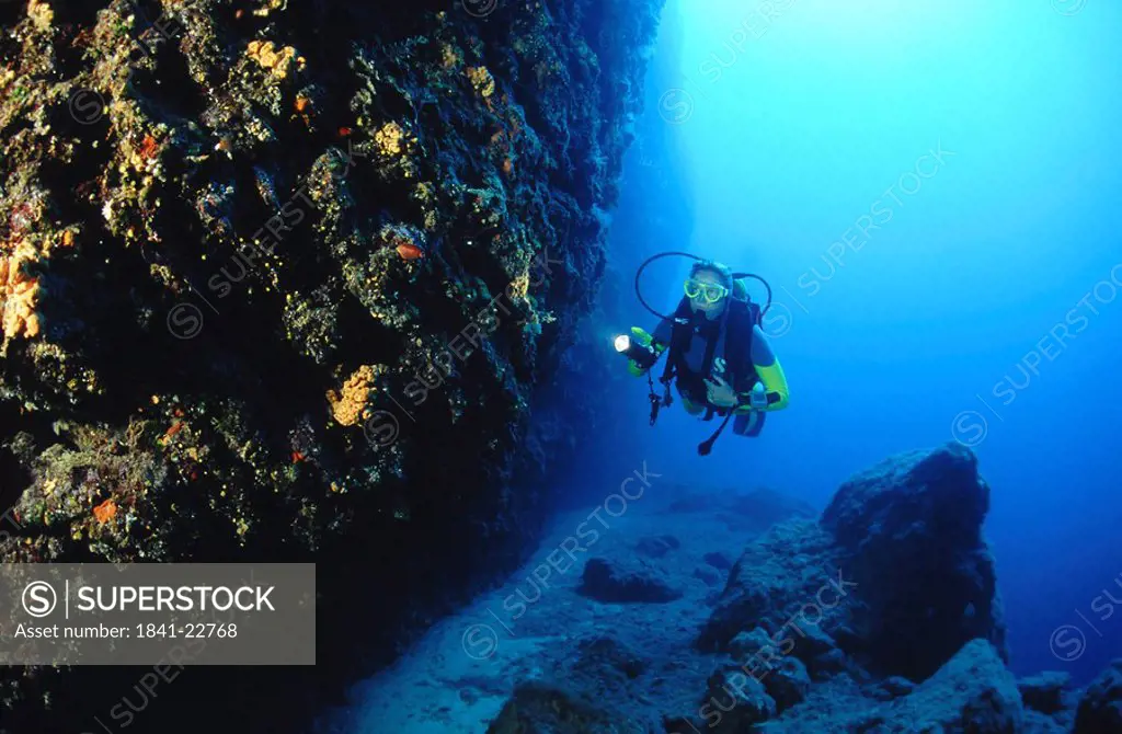 Scuba diver exploring under the sea, Grotto Cave, Corfu Island, Greece