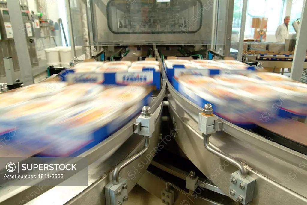 Dairy products in motion on conveyor belt at dairy industry