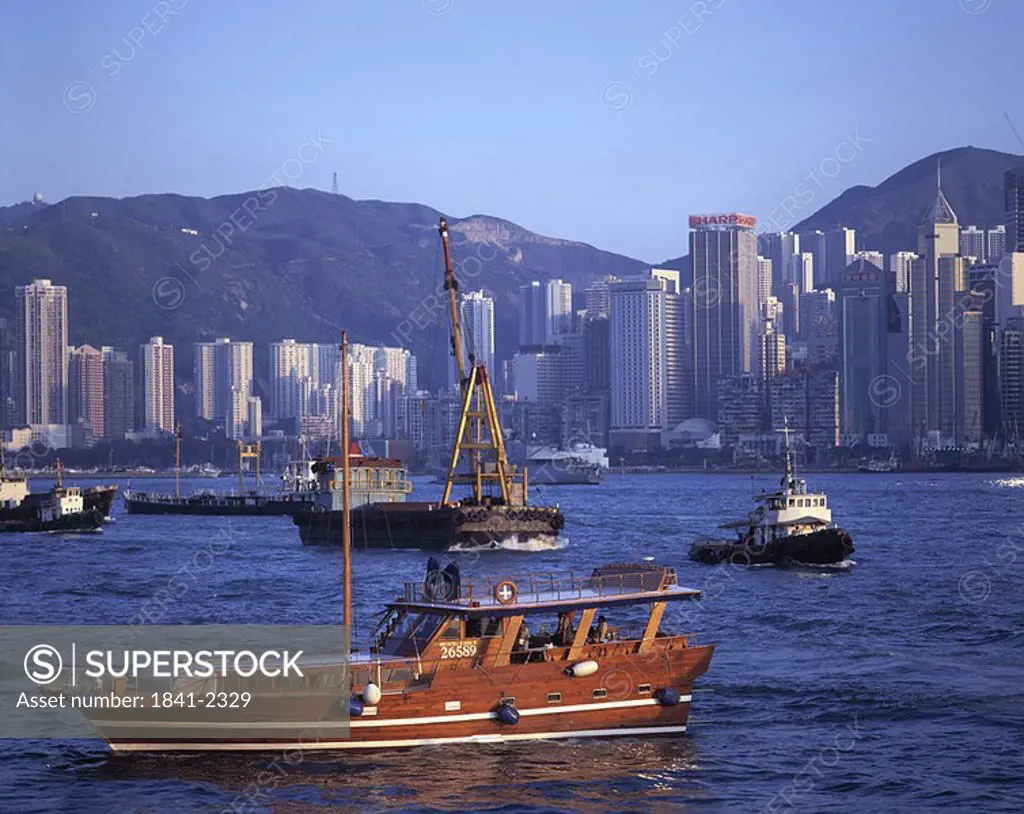 Fishing boats in river with city in background