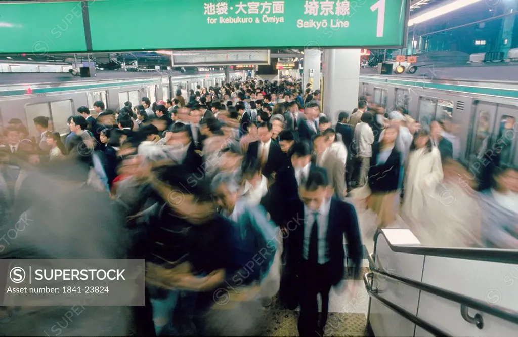 Commuters hurrying on escalator in subway, Tokyo Prefecture, Japan