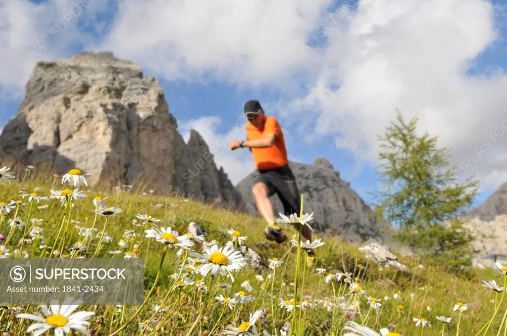 Low angle view of mature man running in field, Trentino_Alto Adige, Italy