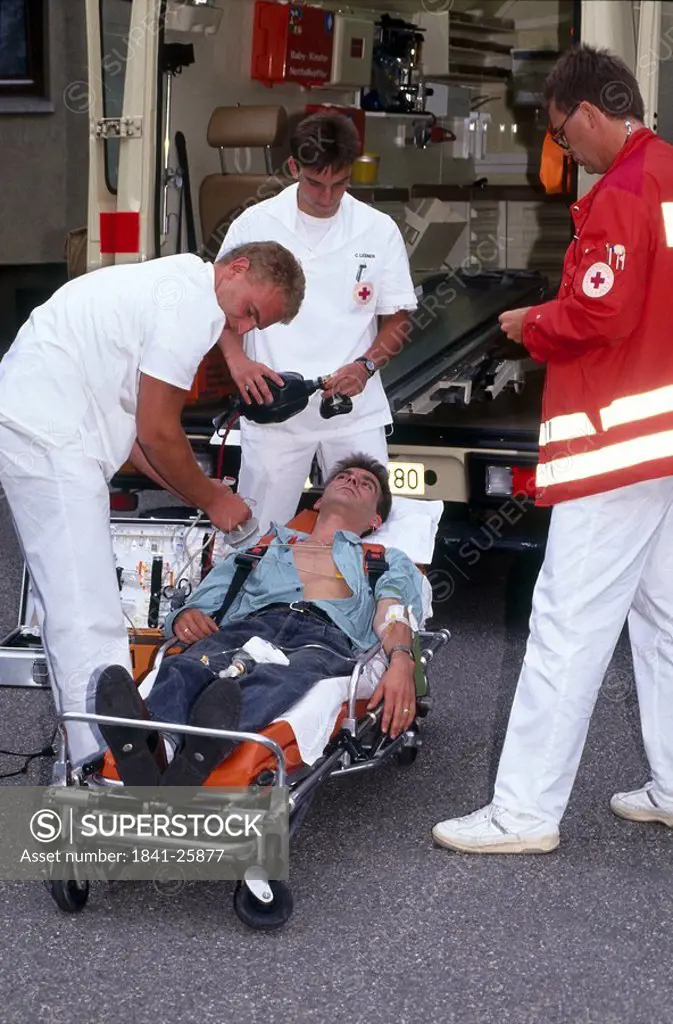 First aid doctor helping patient on stretcher