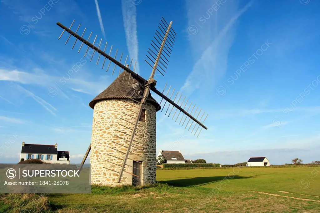 Traditional windmill and houses at coast, Finistere, Brittany, France