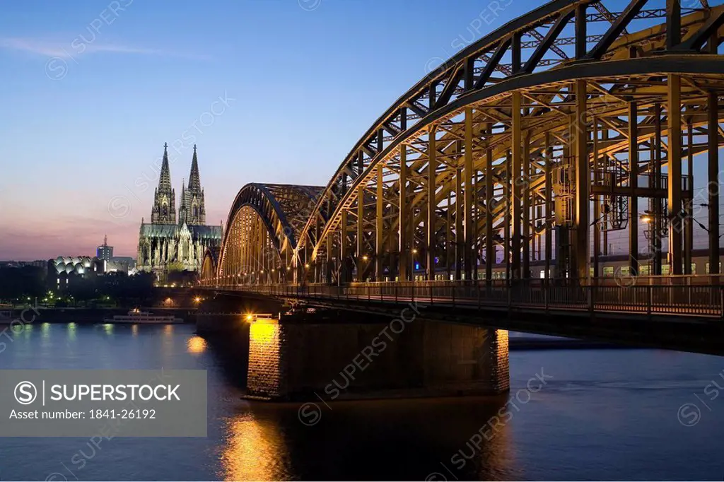 Bridge and church lit up at dusk, Hohenzollern Bridge, Cologne Cathedral, Cologne, Rhineland, North Rhine_Westphalia, Germany