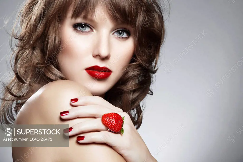Young woman with a ring from a strawberry