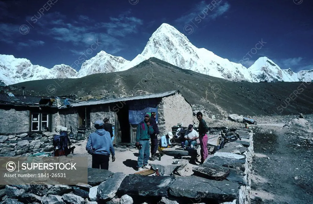 Tourist at lodge with mountains in background, Gorak Shep, Pumori, Kala Patthar, Himalayas, Nepal