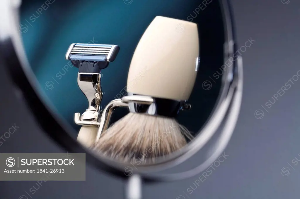 Reflection of shaving brush and razor in mirror
