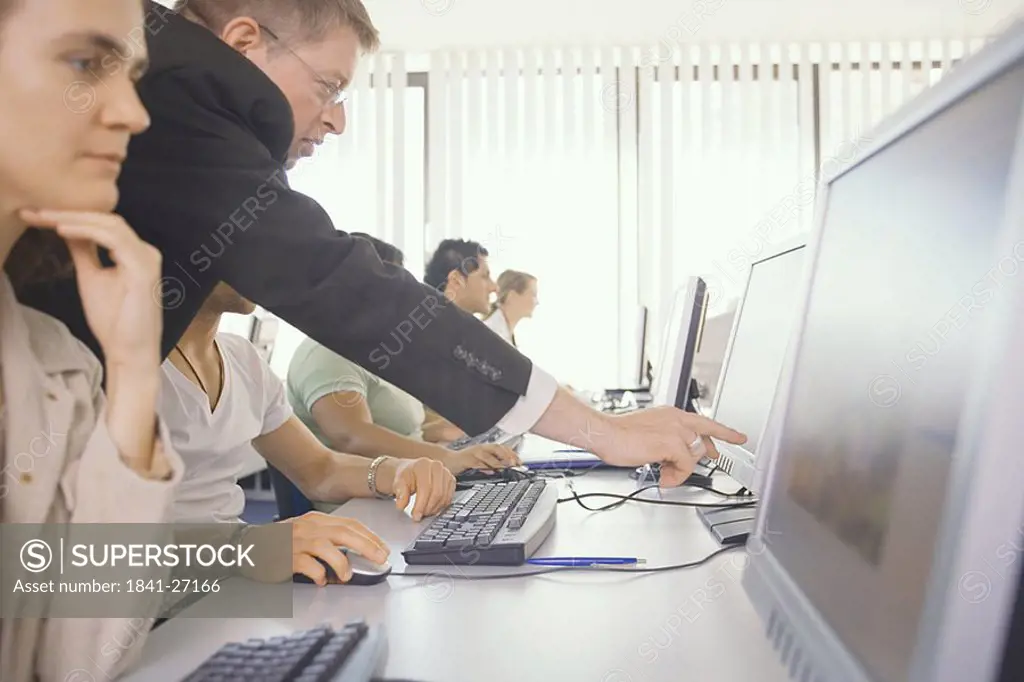 Side profile of businesspeople working on computers