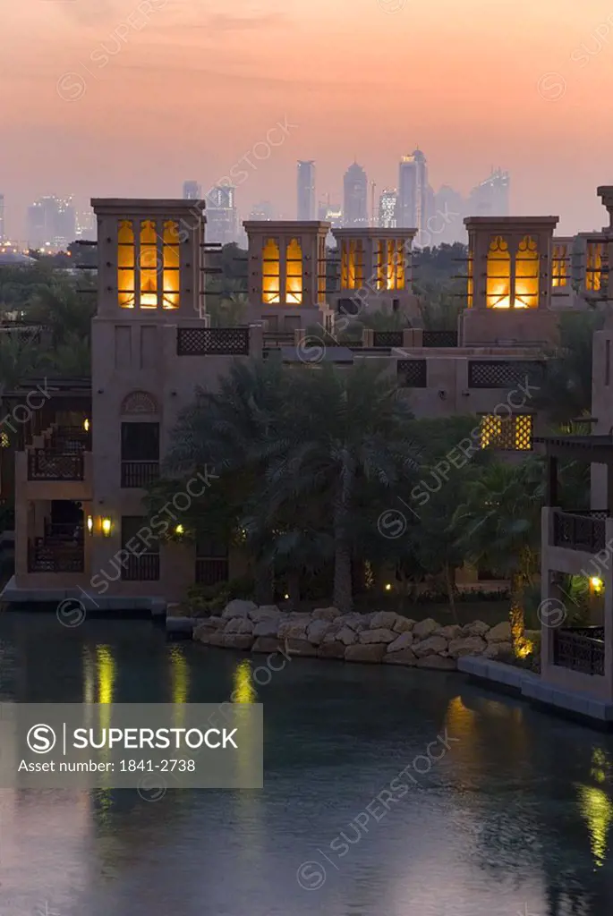 Hotel lit up at waterfront during dusk, Al Qasr Hotel, United Arab Emirates
