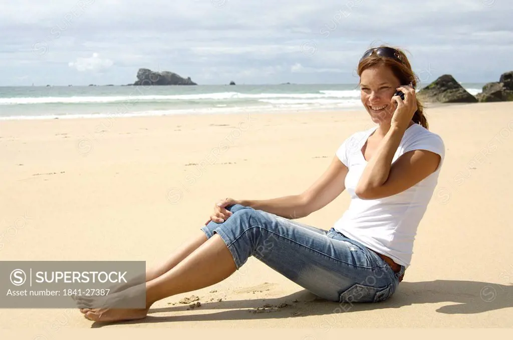 Side profile of woman using mobile phone on beach