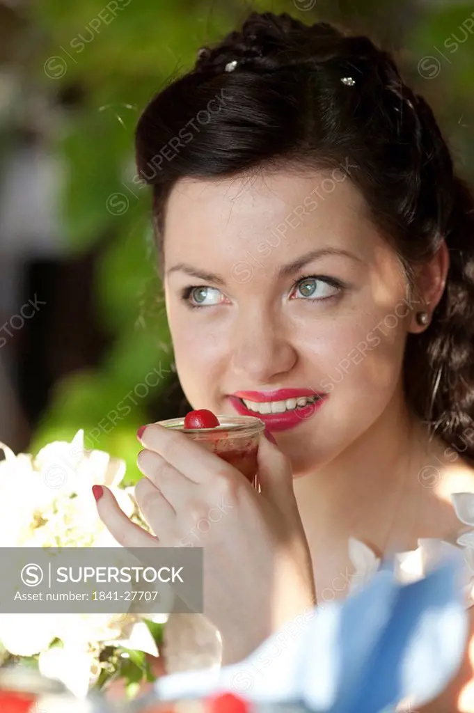 Young woman holding glass with a dessert, portrait