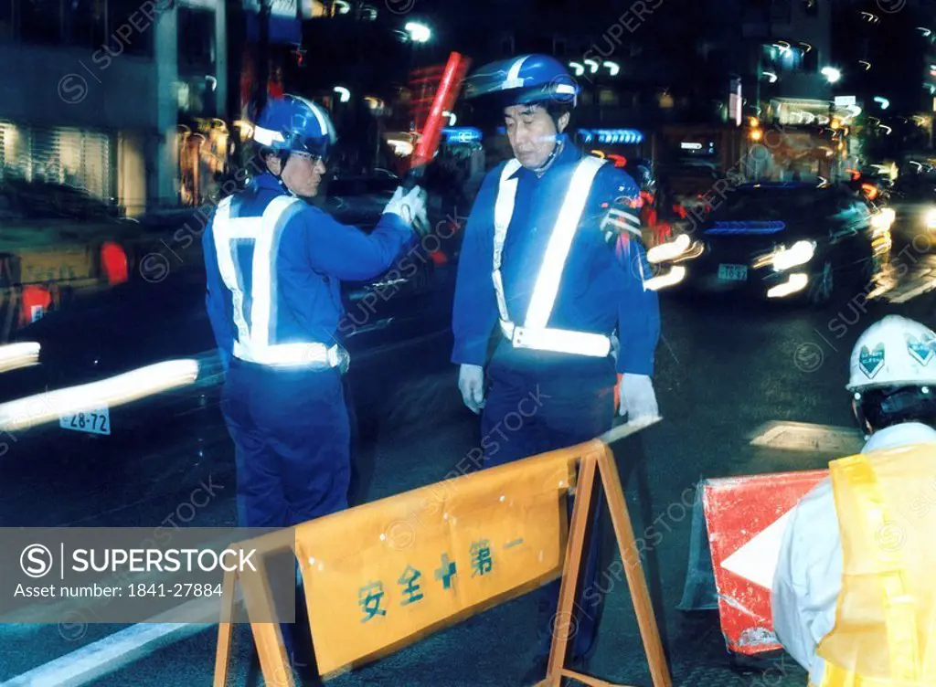 Policemen at construction site on road, Shinjuku, Tokyo, Japan