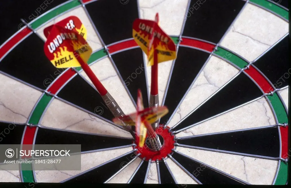 Close_up of three darts on bull´s eye of dart board