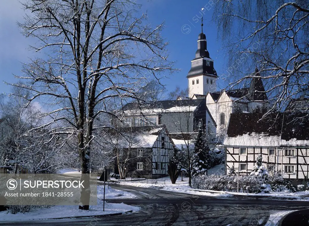 Snow covered trees in front of church, Numbrecht, North Rhine_Westphalia, Germany